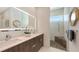 Bathroom featuring double vanity, large mirrors, and glass-enclosed shower with bench at 2135 Hyde Park St, Sarasota, FL 34239