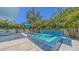 Outdoor hot tub with mosaic tile and waterfall feature, surrounded by lush landscaping and patio seating at 2135 Hyde Park St, Sarasota, FL 34239