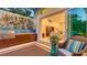 Back patio features outdoor kitchen, modern art, and indoor living space access through sliding doors at 2135 Hyde Park St, Sarasota, FL 34239