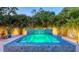 Backyard pool with a waterfall feature surrounded by palm trees and white gravel at 2135 Hyde Park St, Sarasota, FL 34239