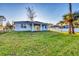 Expansive backyard featuring lush green lawn, mature trees and covered patio at 2258 Margaret Ln, North Port, FL 34286