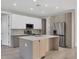 Stylish kitchen with stainless steel appliances, a spacious island, and sleek white cabinetry at 2258 Margaret Ln, North Port, FL 34286