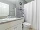 Bathroom featuring a gray accent wall, white fixtures, and functional shelving unit at 2341 Sheila Ln, North Port, FL 34286