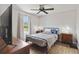 Bright bedroom with a ceiling fan, dresser, nightstands, and view of yard at 2341 Sheila Ln, North Port, FL 34286