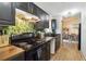 Kitchen featuring black appliances, dark cabinets, stylish backsplash, wooden countertop and hardwood floors at 2341 Sheila Ln, North Port, FL 34286