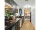 Long kitchen with black cabinets, stainless steel appliances, and a view of the dining area at 2341 Sheila Ln, North Port, FL 34286