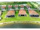 Aerial view of lakeside homes with tile roofs and well-manicured lawns at 24065 Canterwood Way, Venice, FL 34293