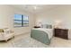 A serene bedroom with a cozy bed, soft lighting, and a view of the tranquil lake at 24065 Canterwood Way, Venice, FL 34293