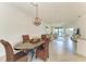 An inviting dining area with stylish woven chairs, an elegant light fixture, and serene water views at 24065 Canterwood Way, Venice, FL 34293