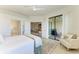 Bright main bedroom with a ceiling fan, plush chair, and sliding glass doors to the lanai at 24065 Canterwood Way, Venice, FL 34293