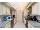 Galley kitchen featuring granite countertops, stainless steel appliances, and light-colored cabinetry at 2715 36Th Avenue E Ter, Bradenton, FL 34208