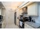 Modern kitchen features stainless steel appliances, granite countertops, and white tiled floors at 2715 36Th Avenue E Ter, Bradenton, FL 34208