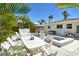Outdoor living with a pristine pool and jacuzzi, comfortable lounge seating, and lush tropical landscaping at 2908 Gulf Dr, Holmes Beach, FL 34217