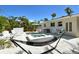 Outdoor living with a pristine pool and jacuzzi, comfortable lounge seating, and lush tropical landscaping at 2908 Gulf Dr, Holmes Beach, FL 34217
