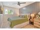 Cozy bedroom with wood-look floors, a modern ceiling fan, and a decorative wood panel accent wall at 2908 Gulf Dr, Holmes Beach, FL 34217