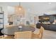 Open-concept dining area with a round table, stylish pendant lighting, and seamless flow to living room at 2908 Gulf Dr, Holmes Beach, FL 34217