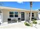 Charming home featuring a modern front door, neutral paint, well manicured landscaping and seating at 2908 Gulf Dr, Holmes Beach, FL 34217