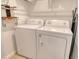 Practical laundry area equipped with a washer, dryer, shelving, and ironing board for convenient laundry tasks at 2908 Gulf Dr, Holmes Beach, FL 34217