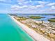 Breathtaking aerial view of a pristine beach with turquoise water and beachfront homes against a beautiful sky at 321 Sorrento Dr, Osprey, FL 34229
