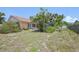 View of the backyard with a screened-in lanai, privacy shrubs and grass at 321 Sorrento Dr, Osprey, FL 34229