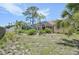 Spacious backyard with lush greenery, mature trees, and screened lanai overlooking the property at 321 Sorrento Dr, Osprey, FL 34229