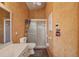 Bathroom featuring a shower with glass door and textured walls with a textured wall finish at 321 Sorrento Dr, Osprey, FL 34229