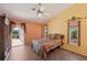Bedroom features a ceiling fan, large windows and a view of the home's screened patio at 321 Sorrento Dr, Osprey, FL 34229