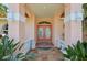 Elegant front entrance with double doors, decorative columns, and lush plants at 321 Sorrento Dr, Osprey, FL 34229