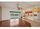 Open-concept living room with wood floors, slider doors, and kitchen view at 321 Sorrento Dr, Osprey, FL 34229