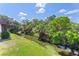 Scenic backyard view with mature trees, a tranquil pond, and lush greenery at 3212 Ramblewood N Dr # 3212, Sarasota, FL 34237