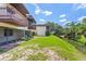 Backyard with a green lawn, water access, mature landscaping, and multiple elevated patios at 3212 Ramblewood N Dr # 3212, Sarasota, FL 34237