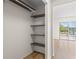 Bedroom closet offers built-in shelving, wood-look flooring, and access to the patio at 3212 Ramblewood N Dr # 3212, Sarasota, FL 34237