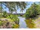 Lush trees and the community's pond create a serene and inviting atmosphere at 3212 Ramblewood N Dr # 3212, Sarasota, FL 34237