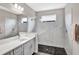 Bright bathroom features a double vanity, stone pebble shower floor, and seamless glass shower doors at 3707 Wild Blossom Pl, Parrish, FL 34219