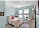 Charming bedroom featuring soft blue walls, carpeted floor, natural light, and comfortable twin bed at 3707 Wild Blossom Pl, Parrish, FL 34219