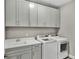Well-equipped laundry room with ample cabinetry and modern washer and dryer at 3707 Wild Blossom Pl, Parrish, FL 34219