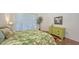 Bright bedroom features shuttered windows, wood floors, light green dresser, and tropical decor at 4208 Balmoral Way, Sarasota, FL 34238