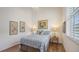 Comfortable bedroom features hardwood floors, paisley bedding, ample light, and a ceiling fan at 4208 Balmoral Way, Sarasota, FL 34238