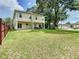 Expansive backyard with lush grass, a privacy fence, and a covered patio area at 4209 W Woodlawn Ave, Tampa, FL 33614