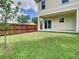 Private backyard with well-manicured lawn, enclosed by a rustic fence, and featuring an open patio at 4209 W Woodlawn Ave, Tampa, FL 33614