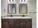 Bathroom featuring a double vanity with granite countertops and dark wood cabinets at 4209 W Woodlawn Ave, Tampa, FL 33614