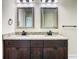 Bathroom featuring a double vanity with granite countertops and dark wood cabinets at 4209 W Woodlawn Ave, Tampa, FL 33614