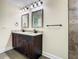 Bathroom featuring double vanity with granite counters, two mirrors, and dark hardware at 4209 W Woodlawn Ave, Tampa, FL 33614