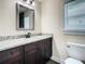 Bathroom boasts granite countertop, dark wood cabinets, and framed mirror at 4209 W Woodlawn Ave, Tampa, FL 33614