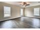 Spacious bedroom with modern ceiling fan, wood-look floors, and three large windows at 4209 W Woodlawn Ave, Tampa, FL 33614