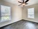 A bright bedroom with dark floors and two windows provides ample natural light at 4209 W Woodlawn Ave, Tampa, FL 33614