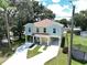 Exterior view of a two-story home with yellow paint and a large driveway at 4209 W Woodlawn Ave, Tampa, FL 33614