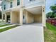 Well-maintained duplex featuring covered parking, modern lighting, and neatly manicured lawn at 4209 W Woodlawn Ave, Tampa, FL 33614