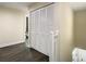 Hallway with dark wood flooring and a closet with bifold doors next to a white bannister and wood railing at 4209 W Woodlawn Ave, Tampa, FL 33614