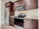 Modern kitchen featuring stainless steel appliances, granite countertops, and stylish dark wood cabinets at 4209 W Woodlawn Ave, Tampa, FL 33614